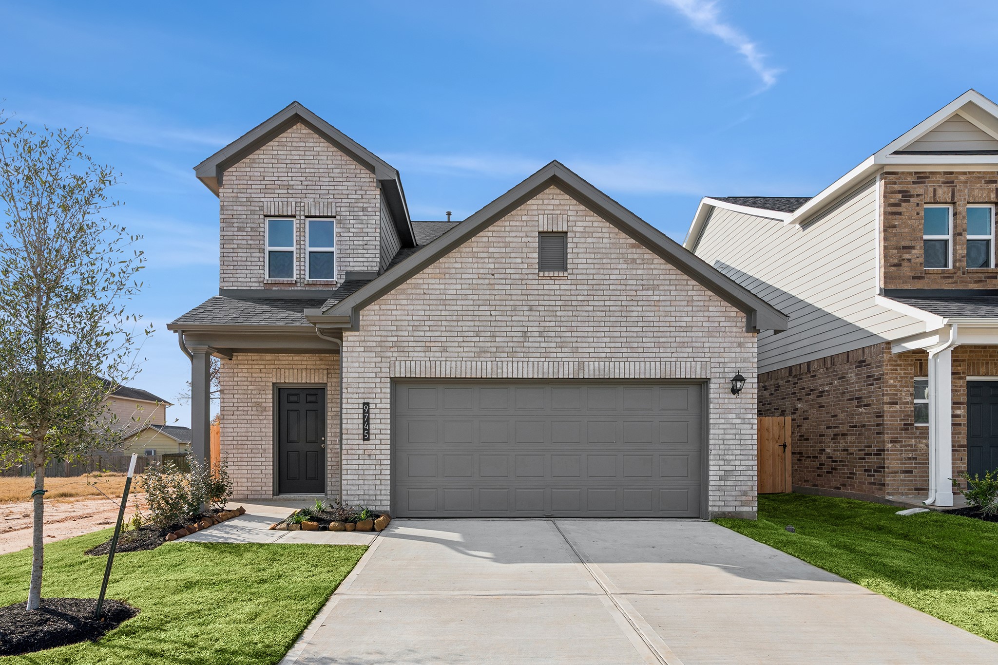 a front view of a house with a yard and garage