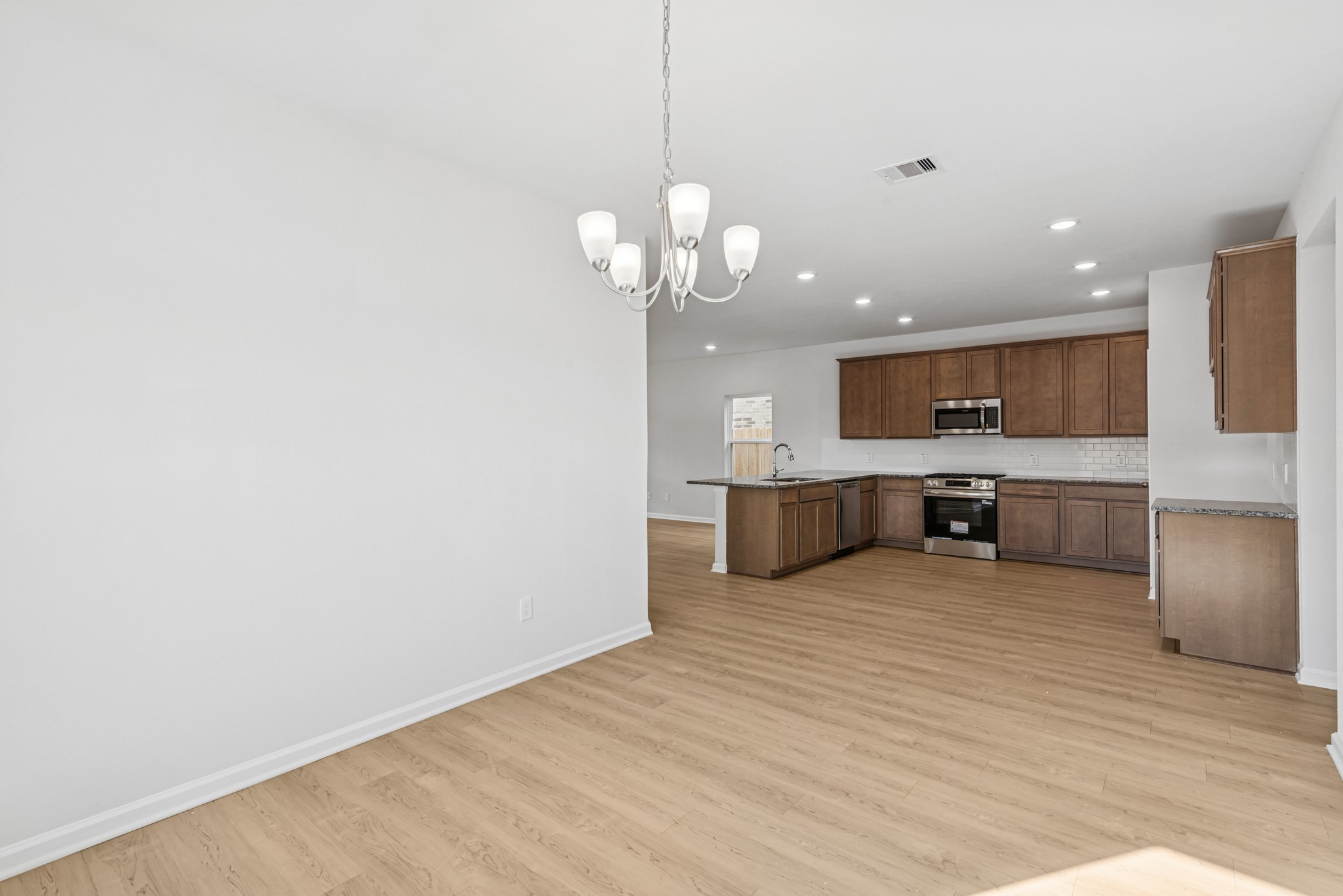 9745 Enclave Ridge Road Willis, TX 77318 - Photo 5 of 27 a view of a kitchen with a sink cabinets and wooden floor