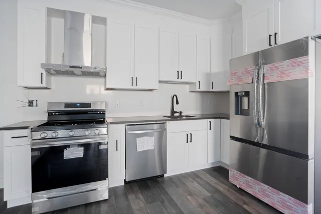 a kitchen with cabinets stainless steel appliances and wooden floor