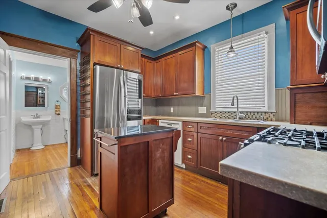 a kitchen with stainless steel appliances granite countertop a sink stove and refrigerator
