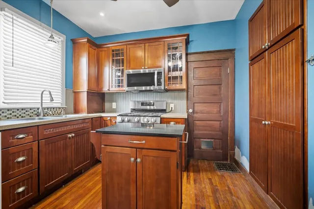 a kitchen with stainless steel appliances granite countertop wooden cabinets a sink and a window