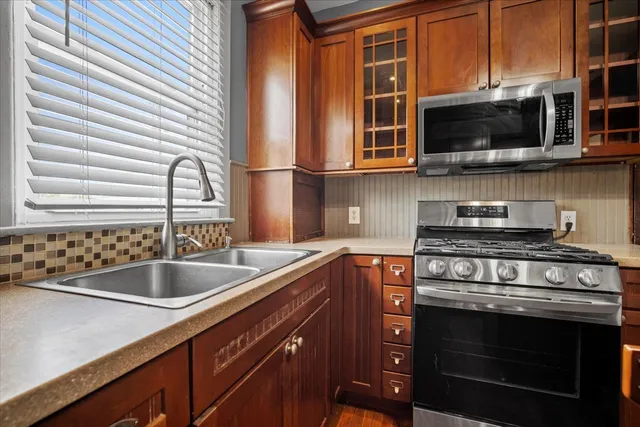 a kitchen with stainless steel appliances granite countertop a sink stove and microwave