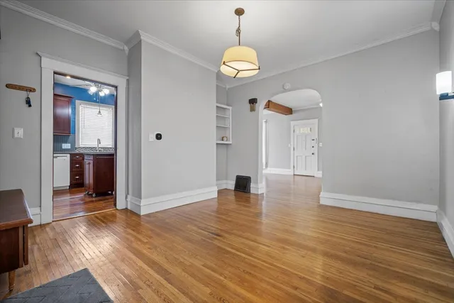 a view of a room with wooden floor staircase and a kitchen space