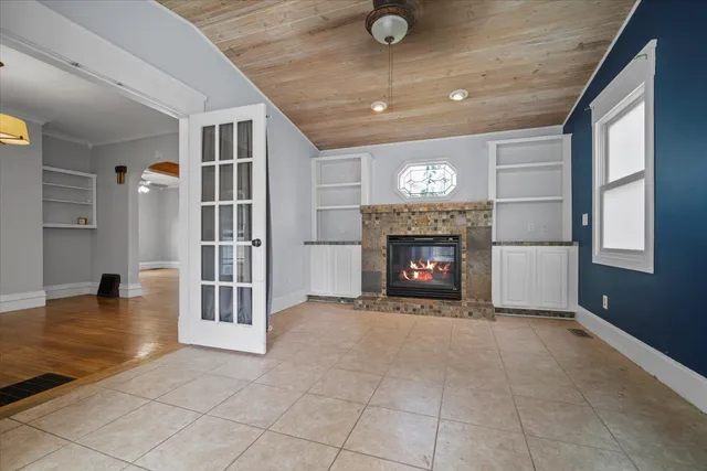 a view of an empty room with a fireplace and a window