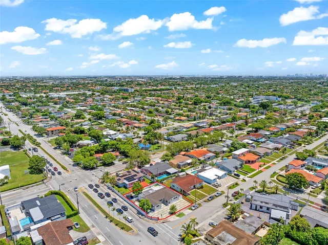 a living room with furniture a flat screen tv and a floor to ceiling window