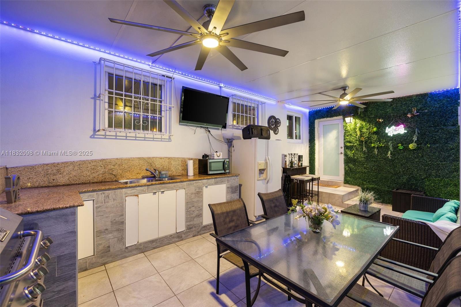 8631 Southwest 16th Terrace Miami, FL 33155 - Photo 60 of 61 a living room with furniture a flat screen tv and a floor to ceiling window