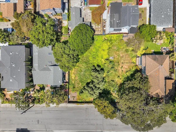 an aerial view of a residential houses with yard