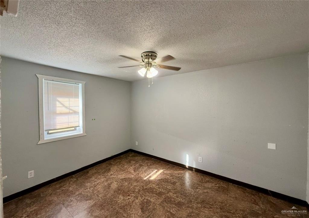 1920 East Iowa Road Edinburg, TX 78542 - Photo 7 of 7 an empty room with a chandelier fan and windows