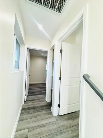 a view of a hallway with wooden floor and staircase