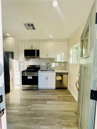 a kitchen with stainless steel appliances kitchen island granite countertop a stove and a refrigerator
