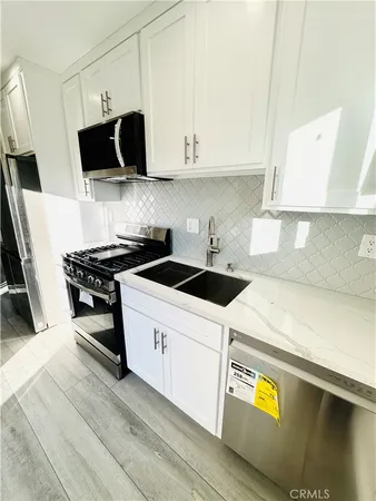 a kitchen with stainless steel appliances a sink a stove and a microwave