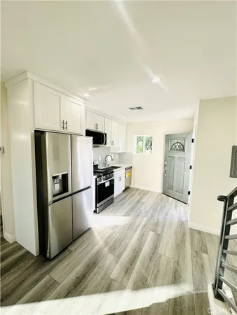 a kitchen with granite countertop a refrigerator and a stove top oven
