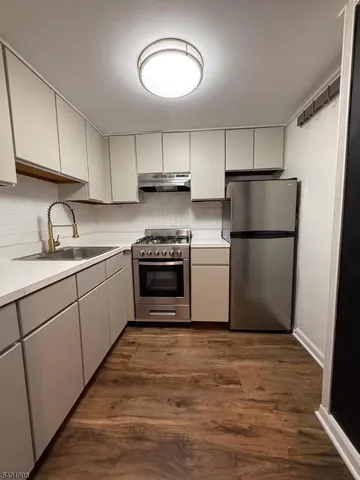 a kitchen with sink cabinets and wooden floor
