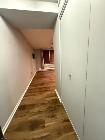 a view of an empty room with window and chandelier