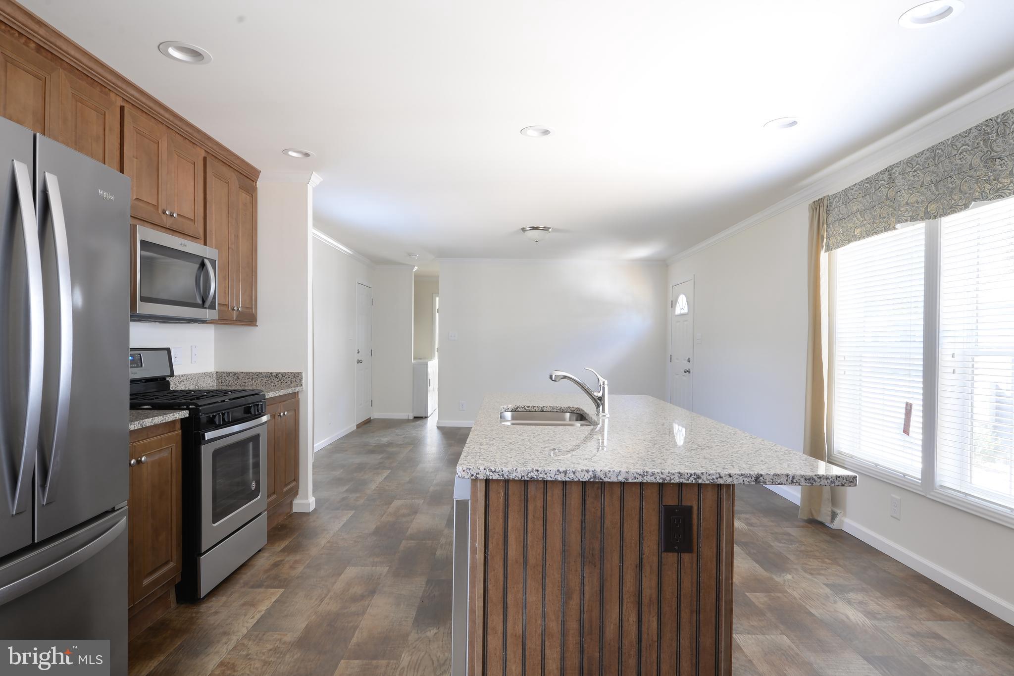 8 Edgewater Drive, Unit 8 Magnolia, DE 19962 - Photo 3 of 13 a kitchen with granite countertop a sink stove and refrigerator