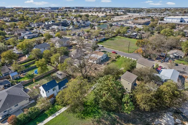 an aerial view of residential houses with outdoor space and trees