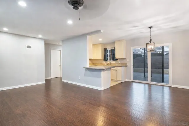 an open kitchen with a refrigerator and microwave