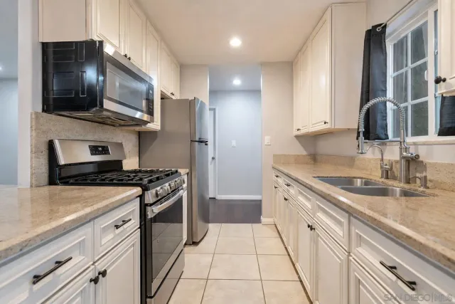 a kitchen with stainless steel appliances granite countertop a sink stove and microwave