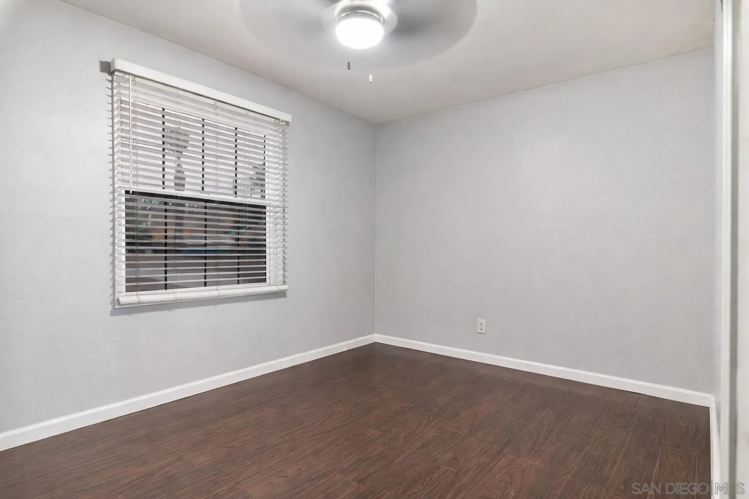 557 Parkbrook Street Spring Valley, CA 91977 - Photo 5 of 8 an empty room with wooden floor and windows