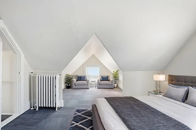 a spacious bedroom with a bed and a chandelier