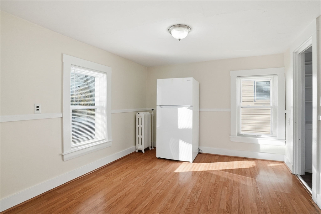 10 Charles Street, Unit 2 Winthrop, MA 02152 - Photo 5 of 22 an empty room with wooden floor and windows