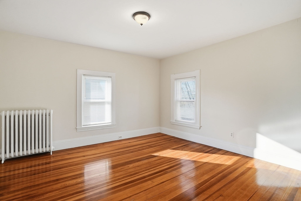 10 Charles Street, Unit 2 Winthrop, MA 02152 - Photo 8 of 22 an empty room with wooden floor and windows