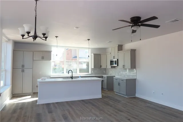a kitchen with kitchen island a sink and a stove top oven