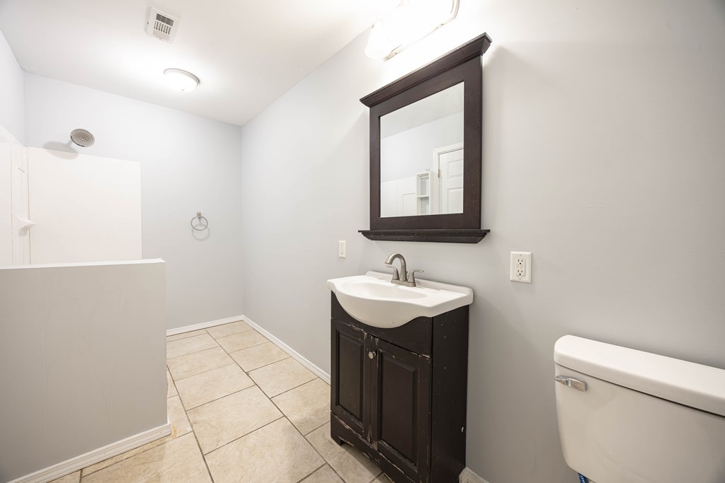 2113 Summerville Road Phenix City, AL 36867 - Photo 23 of 37 a bathroom with a toilet a sink a mirror and vanity