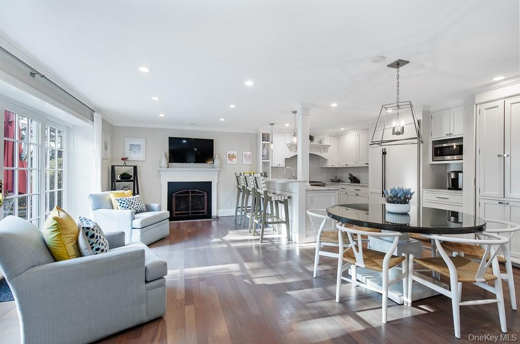 94 Round Hill Road Scarsdale, NY 10583 - Photo 15 of 46 Family room featuring a fireplace and glass doors to the property is open to the eat-in kitchen with lovely breakfast area.
