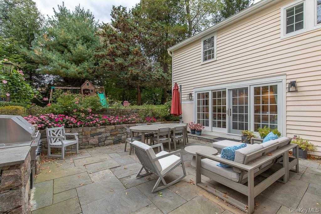 94 Round Hill Road Scarsdale, NY 10583 - Photo 37 of 46 The idyllic stone patio features a lovely sitting area and a built-in grill; conveniently and beautifully positioned and accessible from the kitchen/family room and the formal living room.