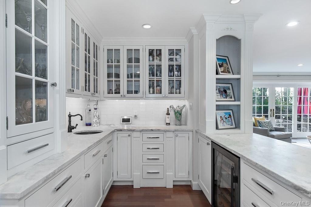 94 Round Hill Road Scarsdale, NY 10583 - Photo 9 of 46 Butler's pantry with wet bar, built-in wine fridge, Italian marble countertops, and custom cabinetry with white inlays positioned off the dining room adjoins the eat-in kitchen.