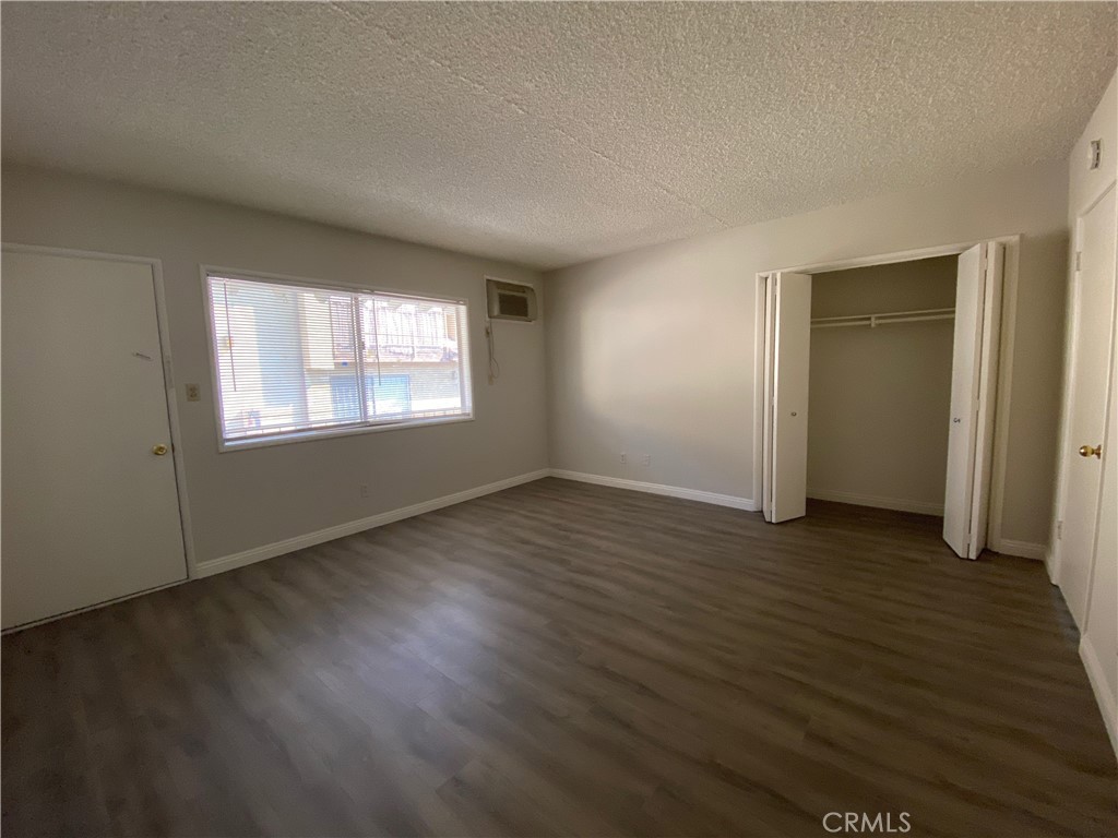 320 North Stoneman Avenue, Unit E Alhambra, CA 91801 - Photo 5 of 6 an empty room with wooden floor and windows