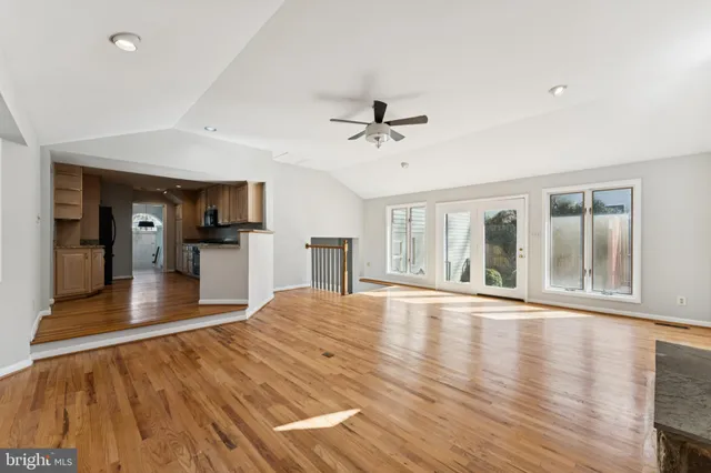 a view of an empty room with window and wooden floor