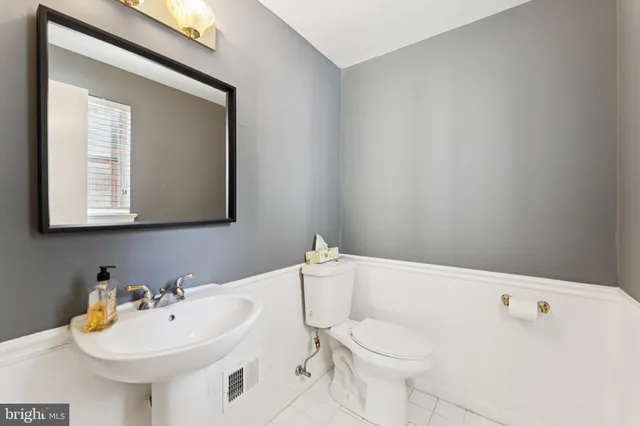 a bathroom with a sink a toilet and mirror