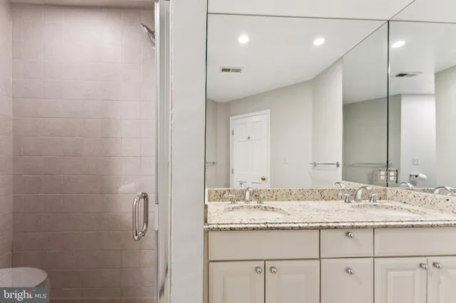 a bathroom with a granite countertop sink a toilet and a mirror