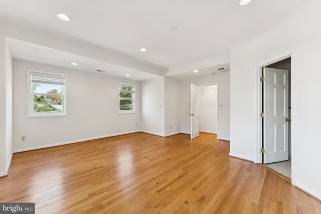 a view of empty room with wooden floor and window