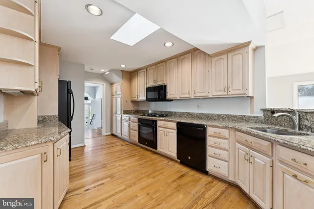 a kitchen with granite countertop a sink stove and refrigerator