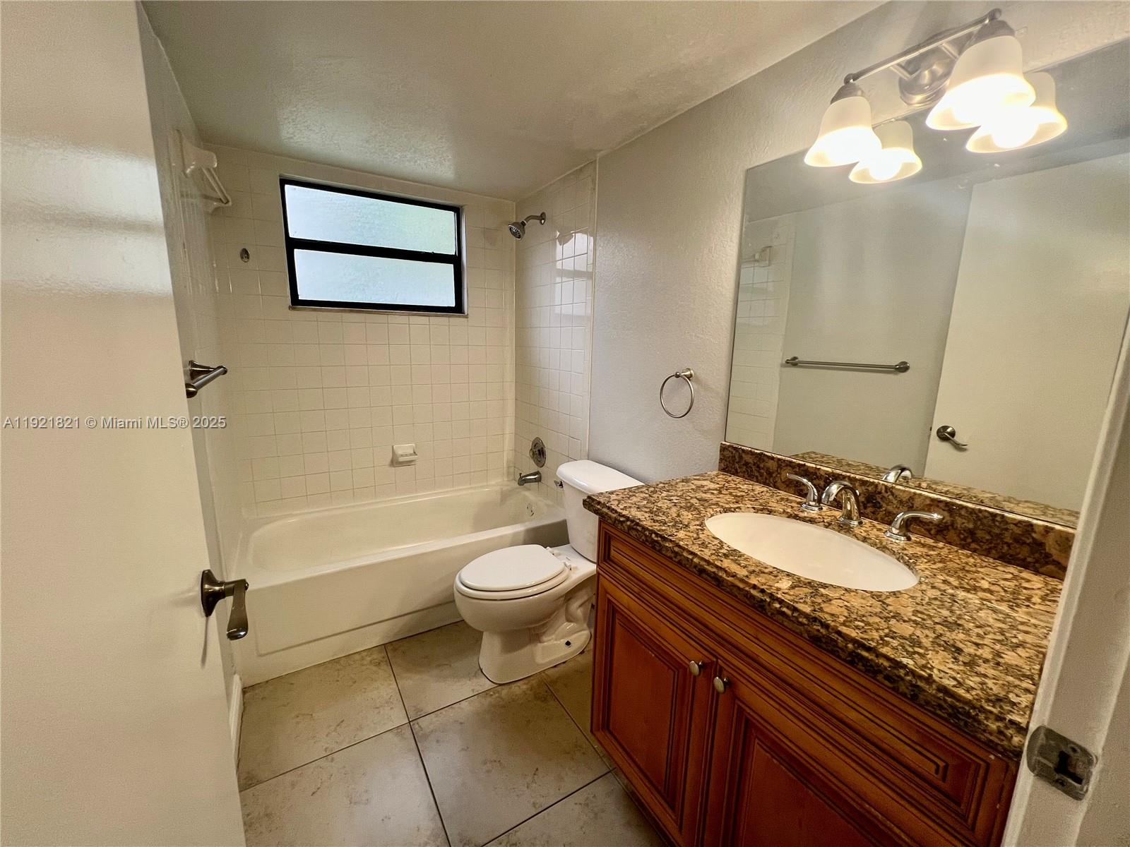 1477 Lake Crystal Drive, Unit F West Palm Beach, FL 33411 - Photo 13 of 16 a bathroom with a granite countertop sink mirror vanity and toilet