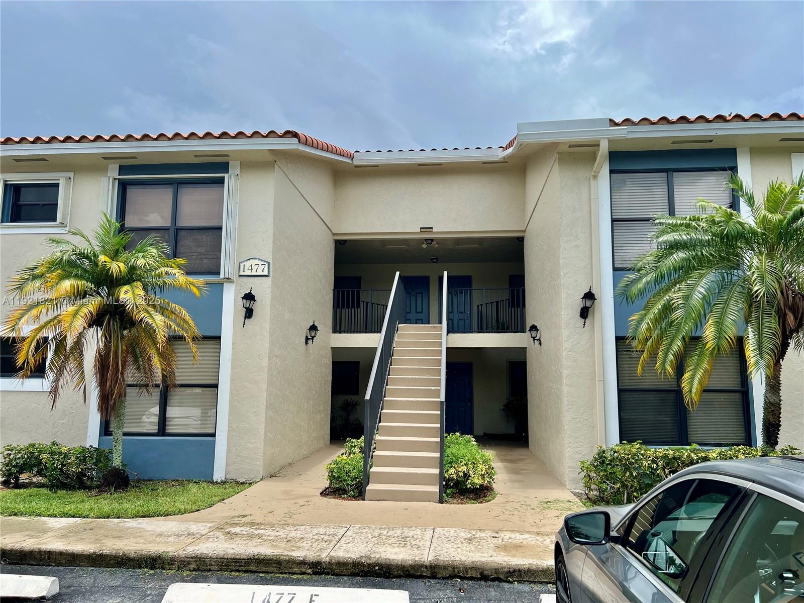 1477 Lake Crystal Drive, Unit F West Palm Beach, FL 33411 - Photo 14 of 16 a view of a house with a patio and a yard