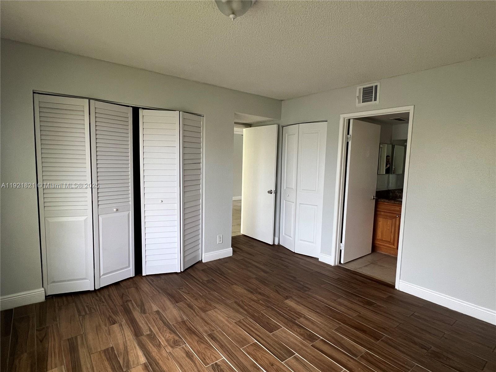 1477 Lake Crystal Drive, Unit F West Palm Beach, FL 33411 - Photo 8 of 16 an empty room with wooden floor and closet