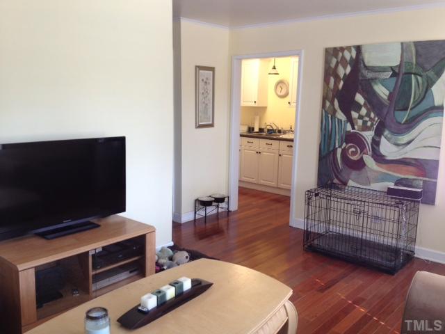709 Daniels Street, Unit A Raleigh, NC 27605 - Photo 3 of 6 a living room with furniture and a flat screen tv