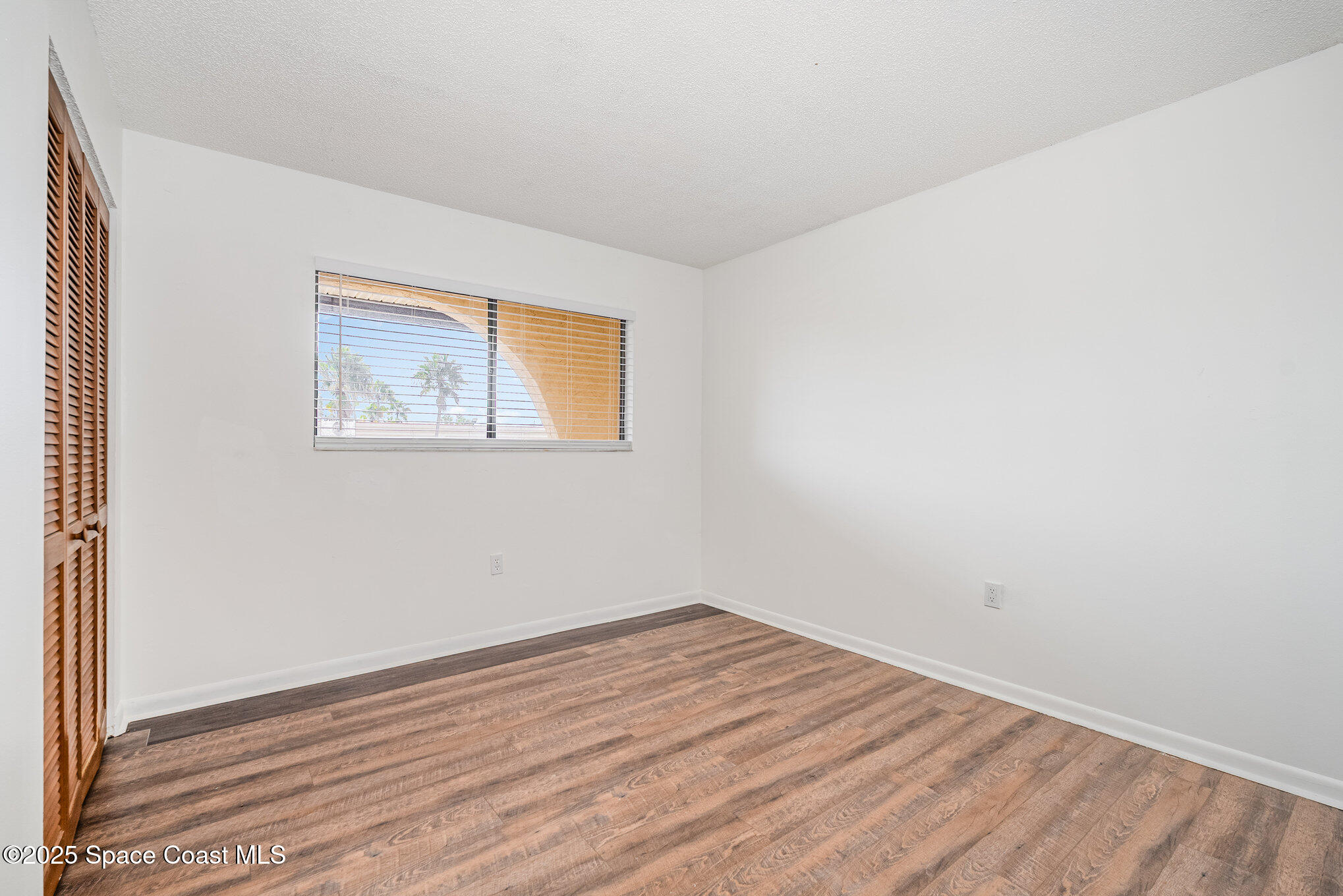 205 Palmetto Avenue, Unit 410 Merritt Island, FL 32953 - Photo 11 of 19 a view of empty room with wooden floor and fan