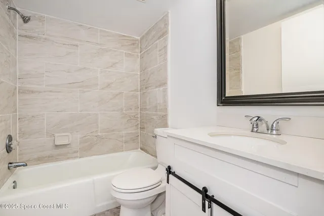 a bathroom with a sink a toilet a mirror a bathtub and shower