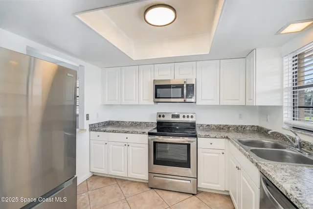 a kitchen with granite countertop a sink stove and refrigerator