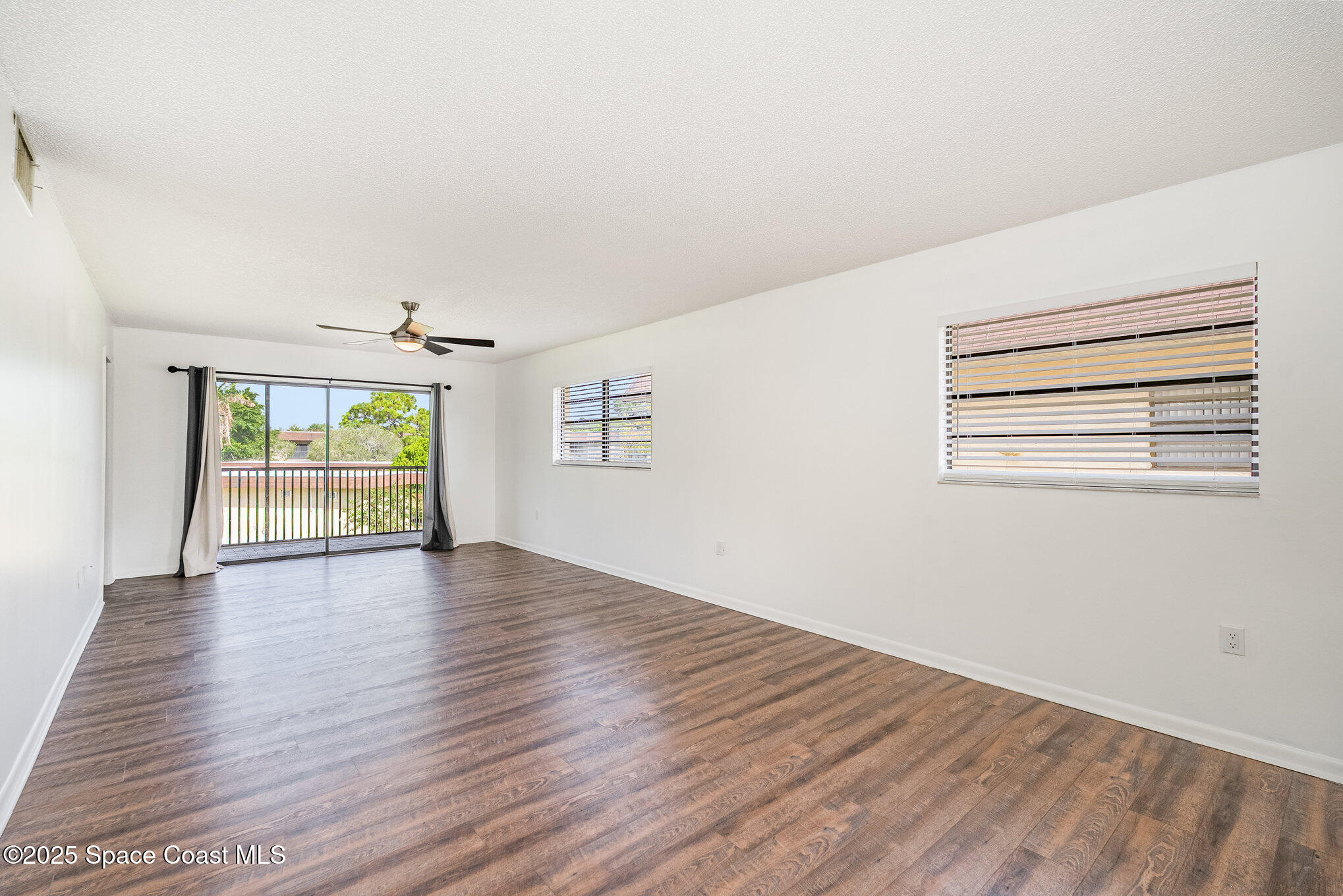 205 Palmetto Avenue, Unit 410 Merritt Island, FL 32953 - Photo 4 of 19 a view of an empty room with wooden floor and a window