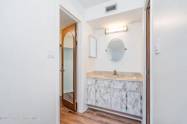 a bathroom with a granite countertop sink and a mirror