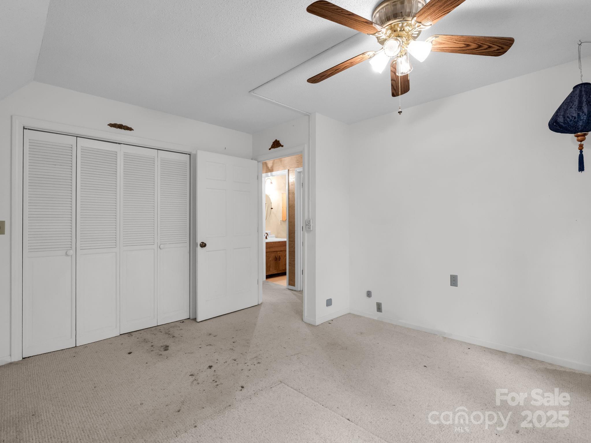 421 Chickadee Lane Brevard, NC 28712 - Photo 23 of 32 an empty room with a chandelier fan and closet area