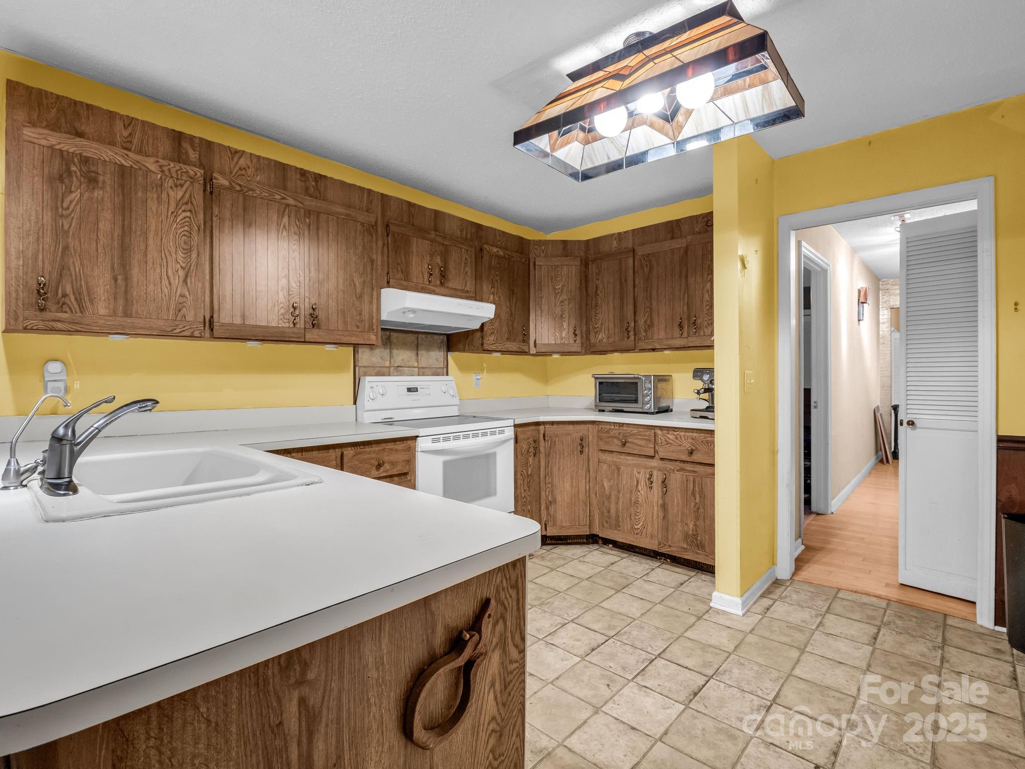 421 Chickadee Lane Brevard, NC 28712 - Photo 10 of 32 a kitchen with a sink a stove cabinets and wooden floor