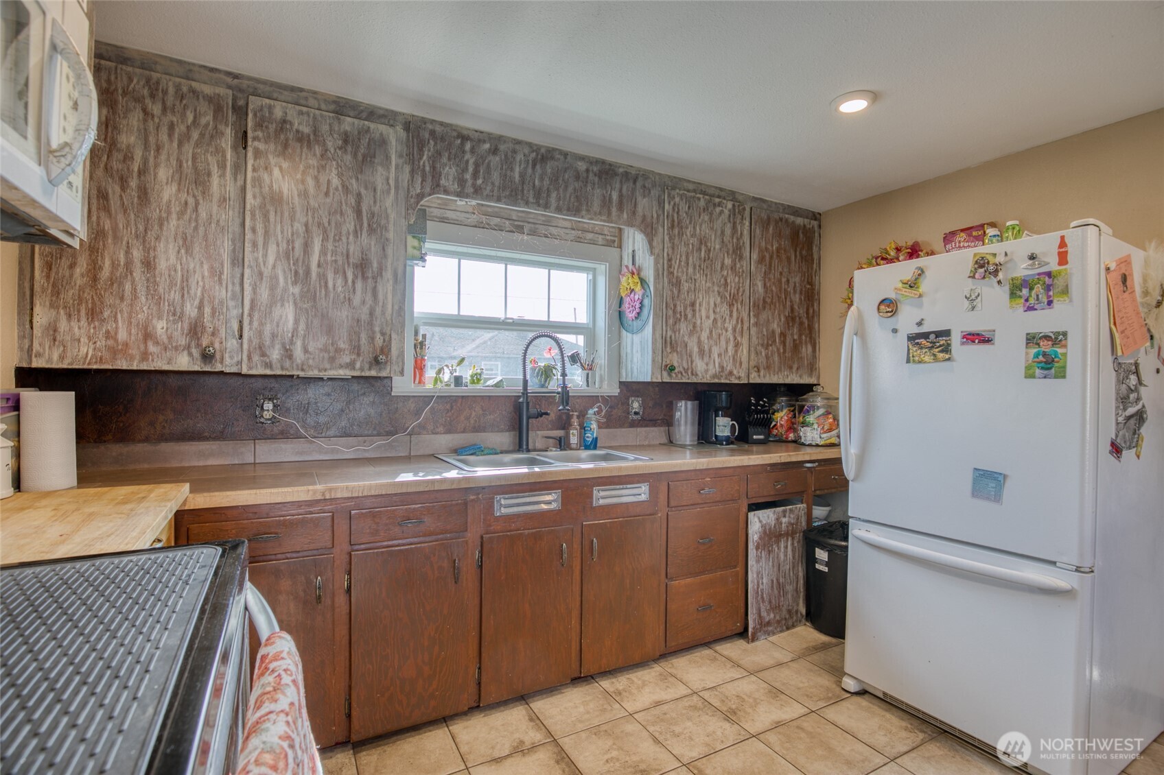 823 West 3rd Street Aberdeen, WA 98520 - Photo 11 of 40 a kitchen with a sink a refrigerator and cabinets