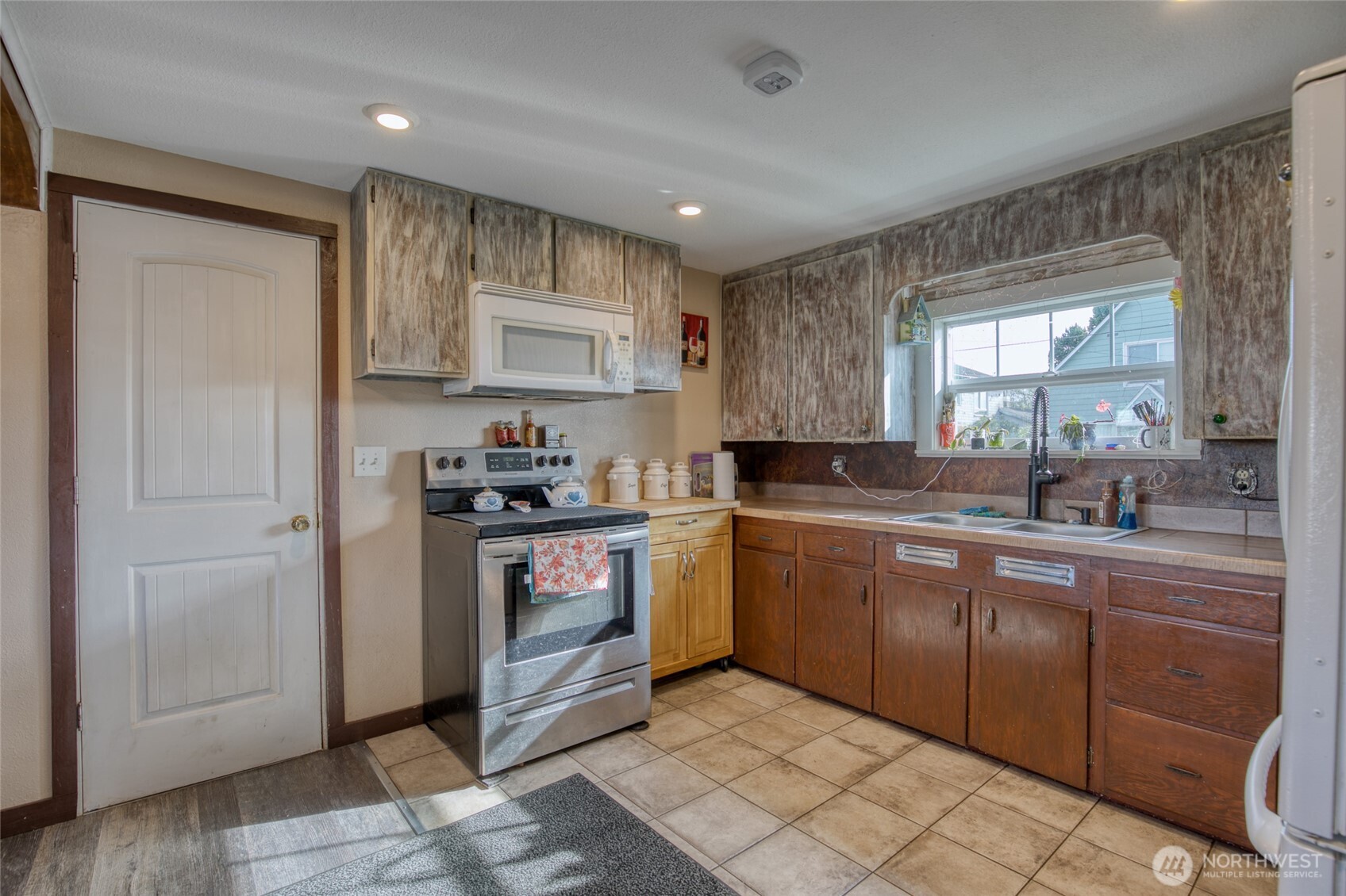 823 West 3rd Street Aberdeen, WA 98520 - Photo 13 of 40 a kitchen with stainless steel appliances granite countertop a refrigerator sink and cabinets